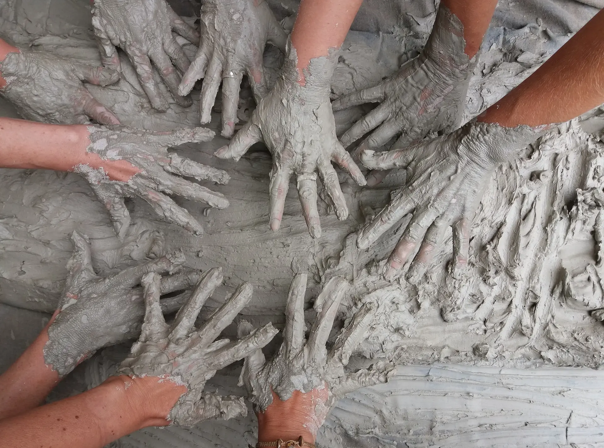 people's hand on gray mud